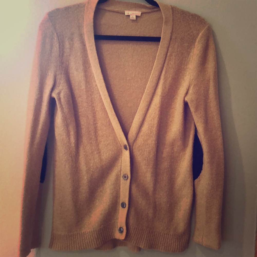 Tan cardigan with blue elbow patches.